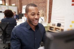 A man in the office talking on the phone